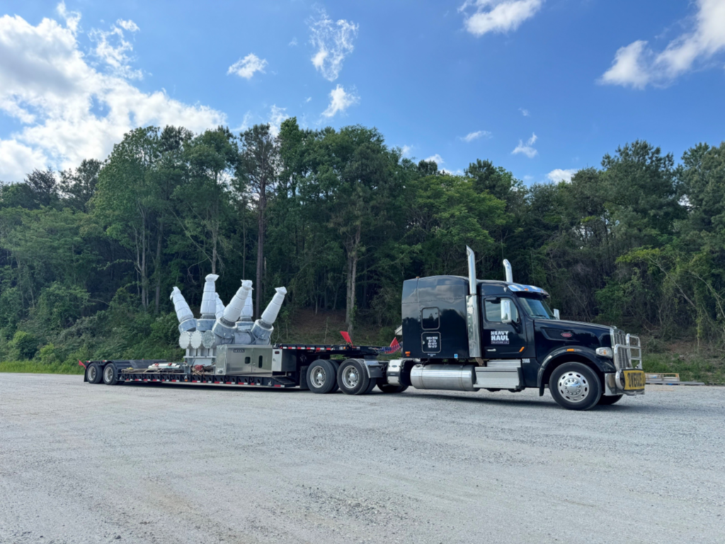 Heavy haul transport of electrical substation equipment on a lowboy trailer.