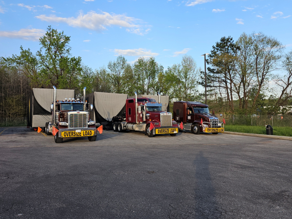 Oversize load heavy haul convoy parked in a staging lot for nationwide specialized transport.
